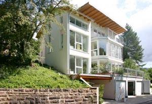 Villa mit weißer Fassade am Berghang im Grünen